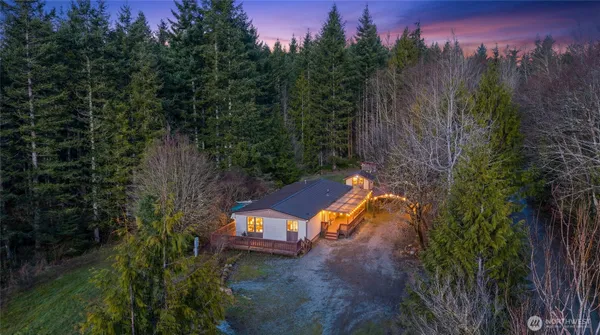 an aerial view of a house with a yard and a large tree