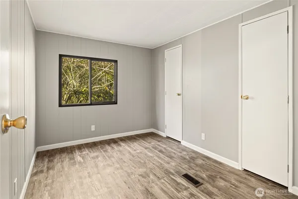 an empty room with a wooden door and shower