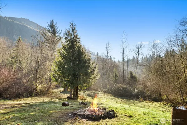 a view of a lush green field with mountains in the background
