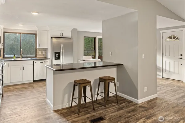 a kitchen with stainless steel appliances granite countertop a stove a sink and a refrigerator
