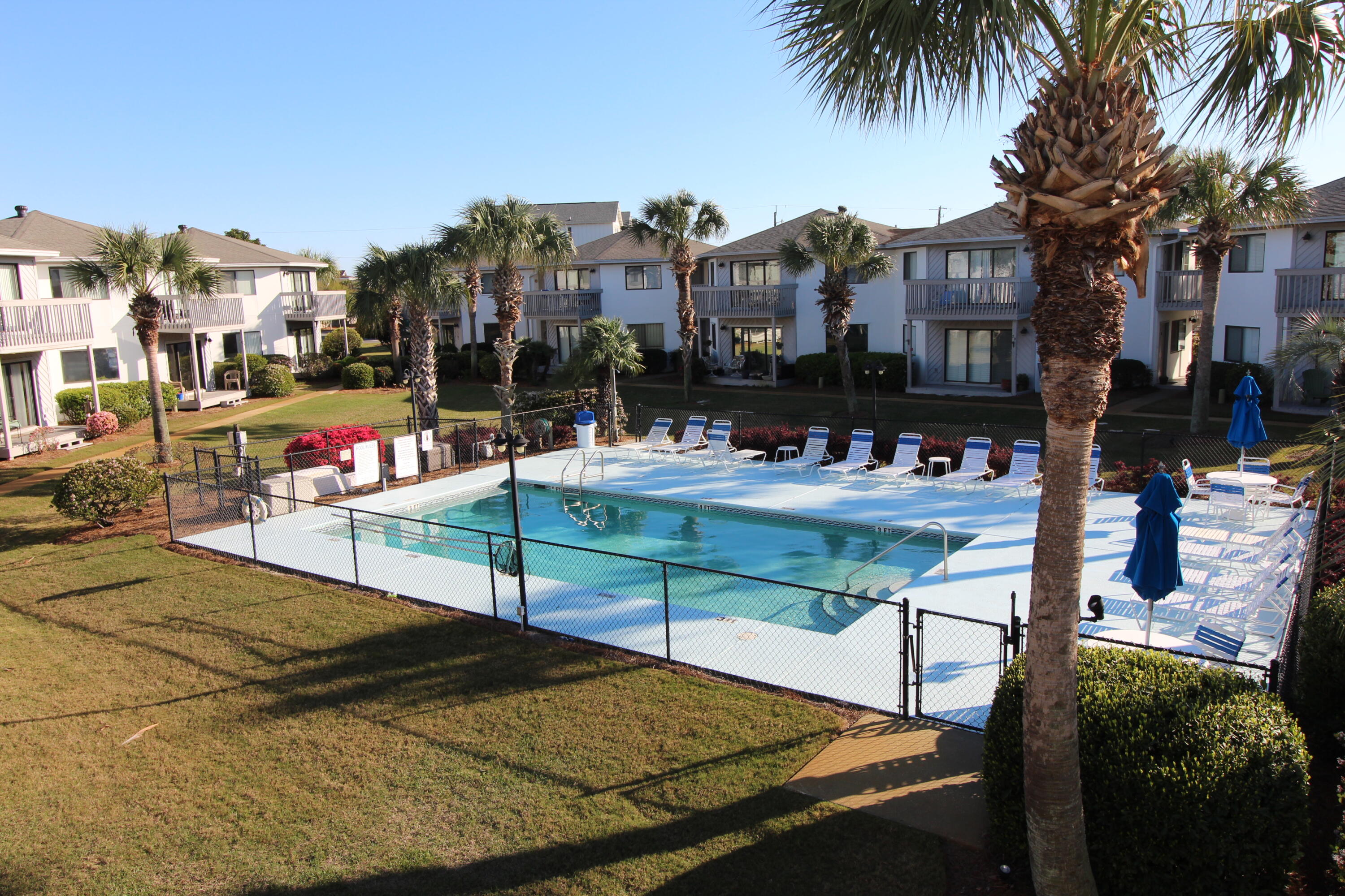 285 Payne Street, Unit 19B Miramar Beach, FL 32550 - Photo 20 of 24 a view of a swimming pool with a bench and trees
