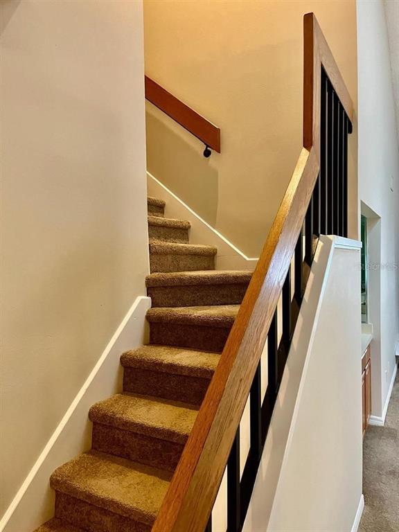 7608 Spring Bay Cove, Unit S Orlando, FL 32819 - Photo 9 of 20 a view of staircase with wooden floor and white walls