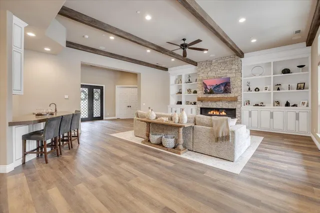 a kitchen with a sink dishwasher and white cabinets with wooden floor
