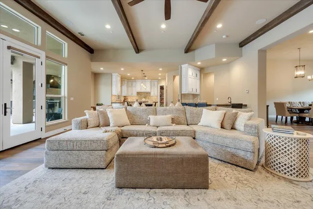 a kitchen with stainless steel appliances kitchen island granite countertop a dining table chairs and sink