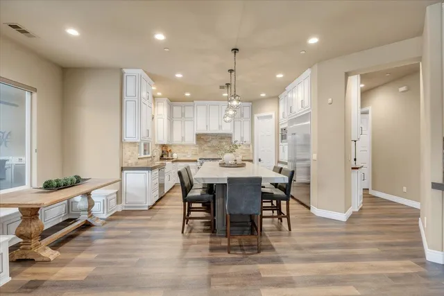 a living room with furniture large window and wooden floor