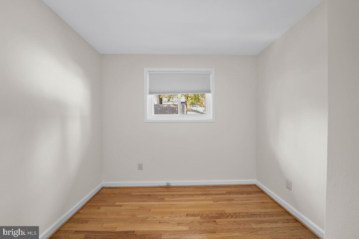 413 Waterford Road Silver Spring, MD 20901 - Photo 20 of 48 a view of an empty room with wooden floor and a window