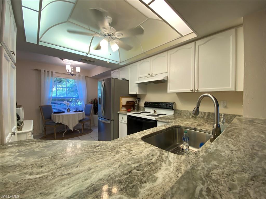a kitchen with stainless steel appliances granite countertop a sink a stove and refrigerator