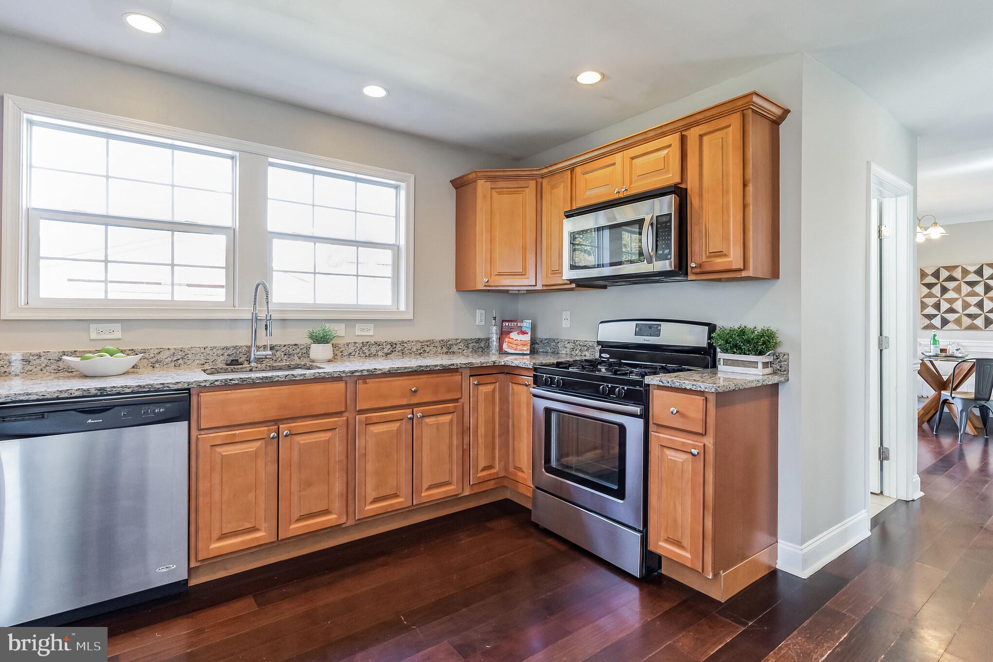 2810 Manoff Road Halethorpe, MD 21227 - Photo 5 of 27 a kitchen with stainless steel appliances granite countertop a stove a sink and a microwave