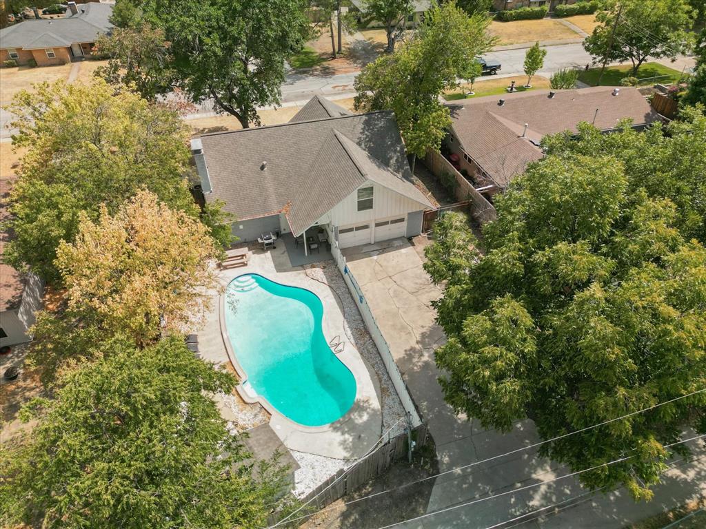 an aerial view of a house with outdoor space and a swimming pool