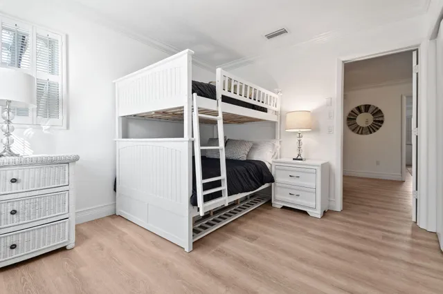 a view of a bedroom with baby bed and cabinets