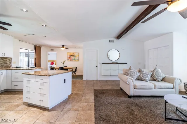 a living room with furniture and kitchen view