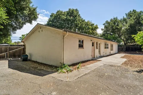 a view of a house with backyard and trees