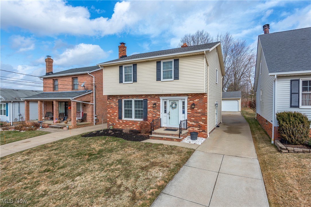 580 Orchardview Road Independence, OH 44131 - Photo 2 of 44 Colonial home featuring an outbuilding, brick siding, a detached garage, a chimney, and a front yard