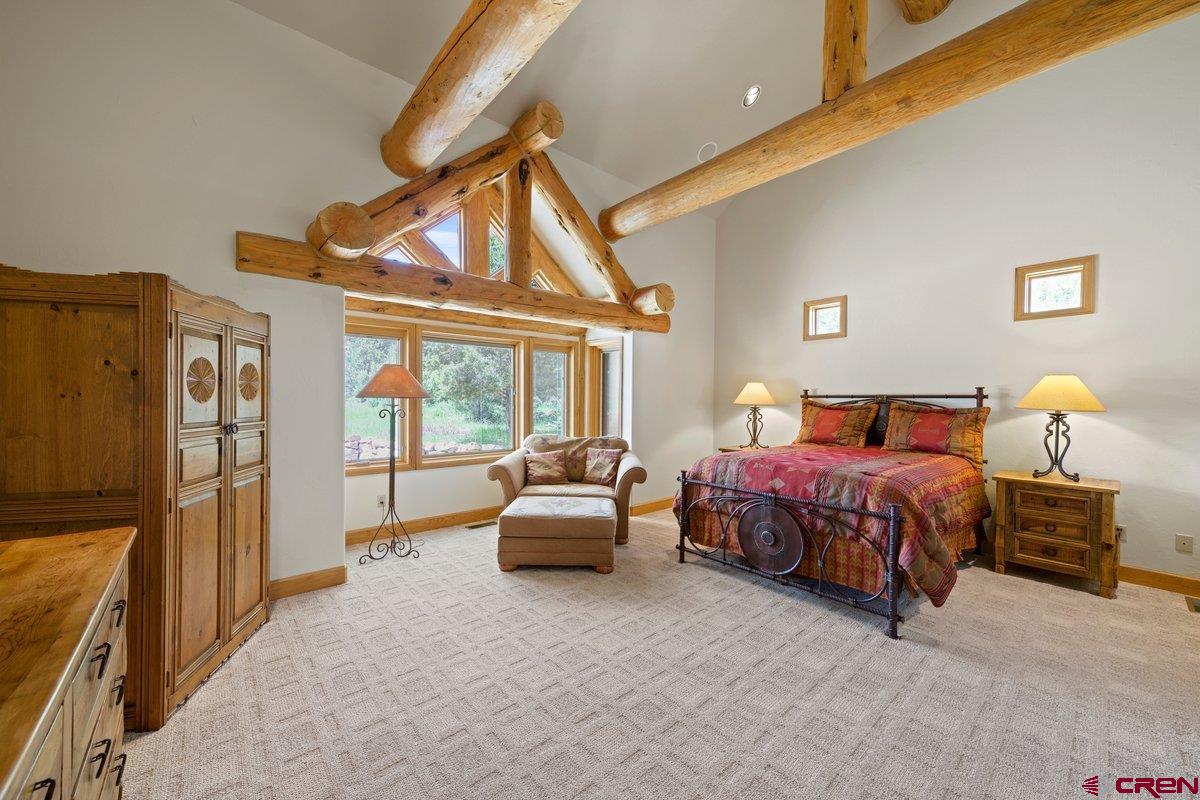 800 Pine Drive Ridgway, CO 81432 - Photo 16 of 35 a bedroom with a bed and a chandelier