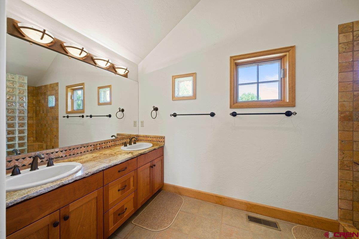 800 Pine Drive Ridgway, CO 81432 - Photo 18 of 35 a spacious bathroom with a double vanity sink and a mirror