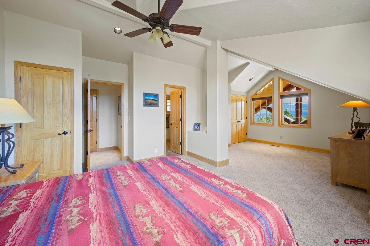 800 Pine Drive Ridgway, CO 81432 - Photo 19 of 35 a bedroom with a bed and a chandelier