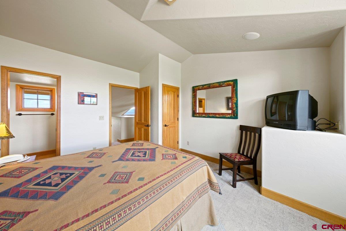 800 Pine Drive Ridgway, CO 81432 - Photo 23 of 35 a bedroom with a bed a couch and two windows