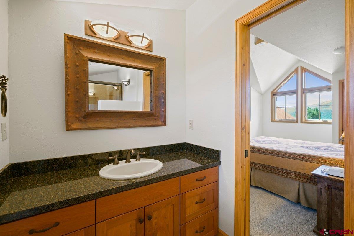 800 Pine Drive Ridgway, CO 81432 - Photo 24 of 35 a bathroom with a granite countertop sink and a mirror