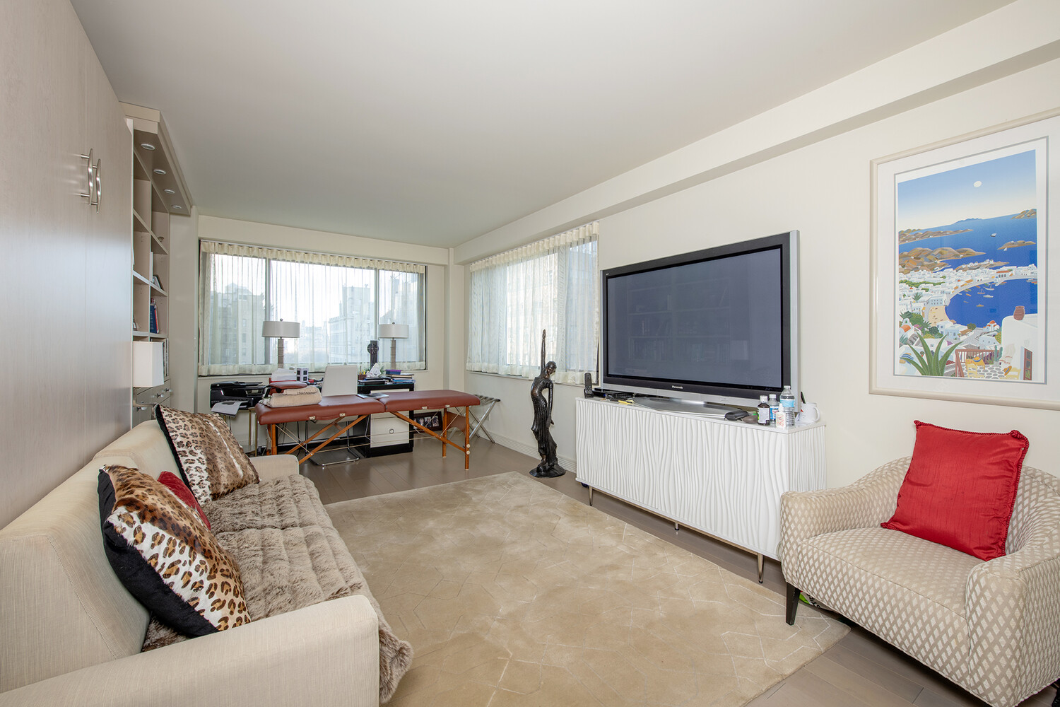 40 East 80th Street, Unit 15A Manhattan, NY 10075 - Photo 6 of 9 a living room with furniture and a flat screen tv