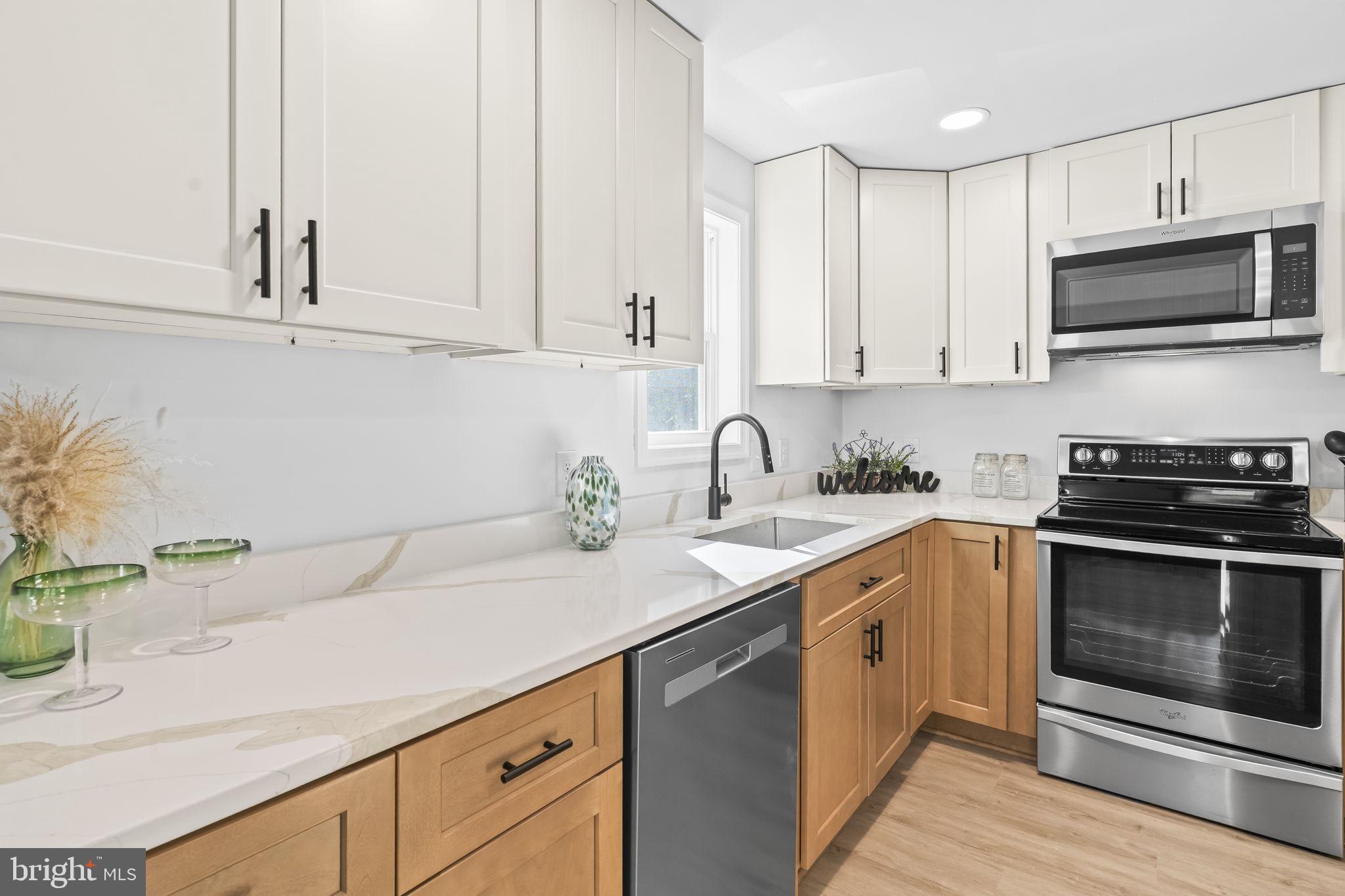 425 Rodeo Road Lusby, MD 20657 - Photo 11 of 33 a kitchen with stainless steel appliances granite countertop a sink a stove and a microwave
