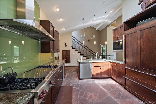 a kitchen with stainless steel appliances granite countertop a stove and a refrigerator
