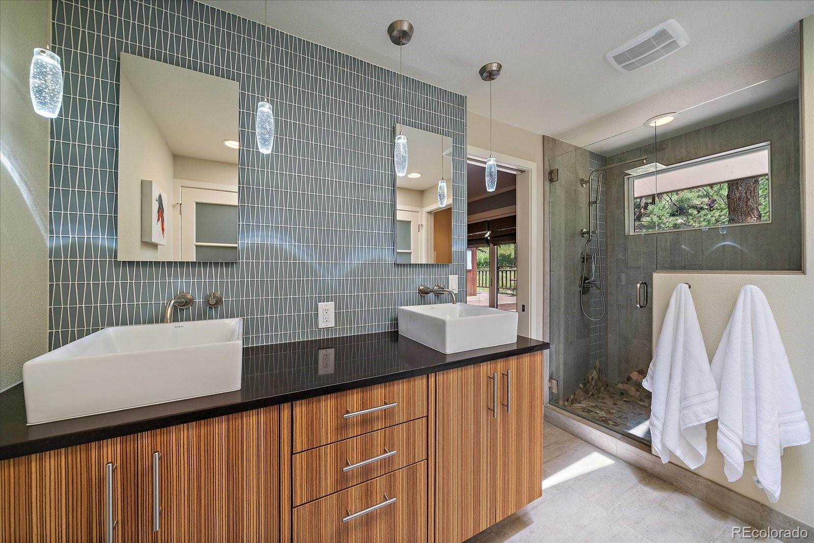 3251 Interlocken Drive Evergreen, CO 80439 - Photo 20 of 43 a bathroom with a sink a mirror and a shower