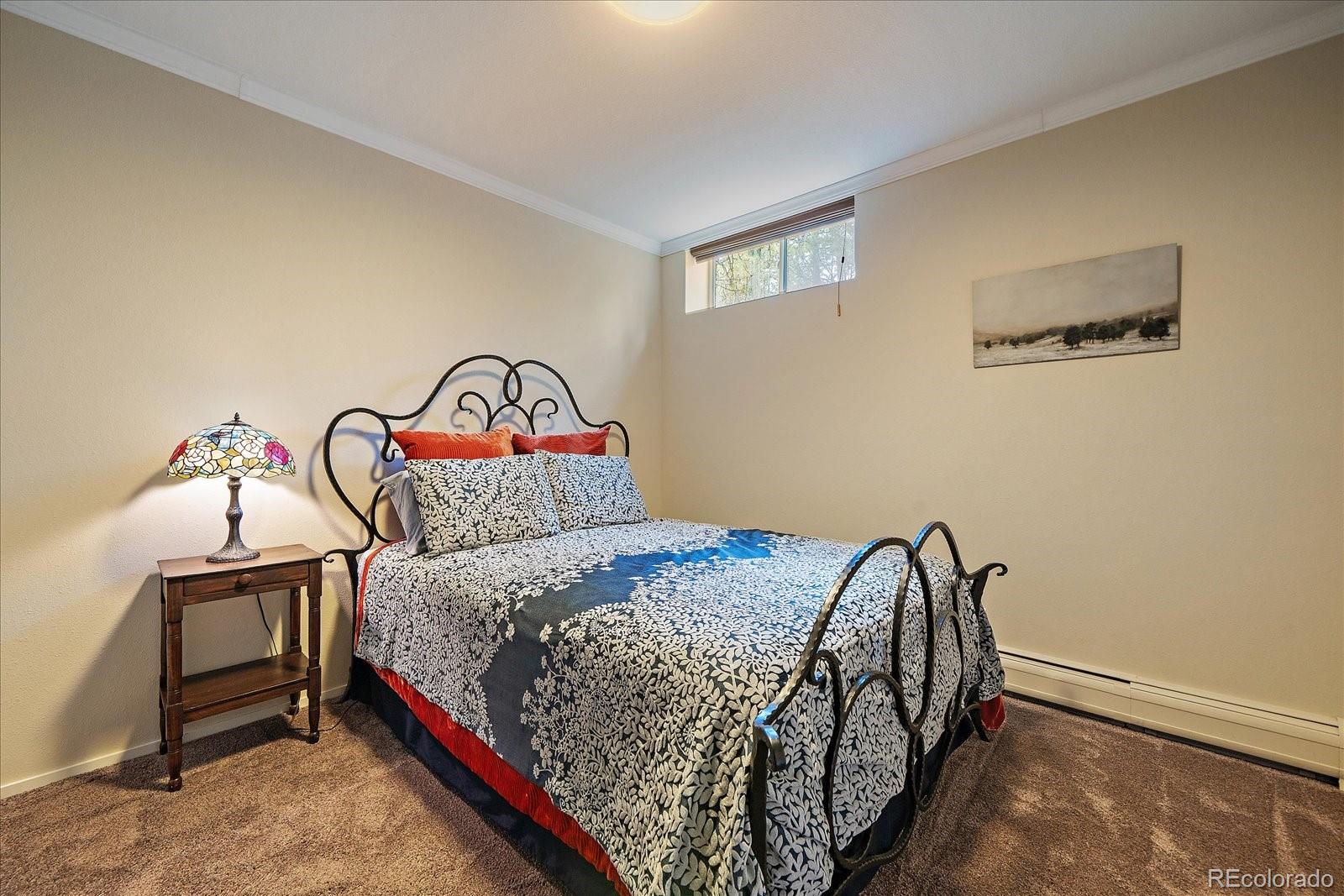 3251 Interlocken Drive Evergreen, CO 80439 - Photo 27 of 43 a bedroom with a bed and a window