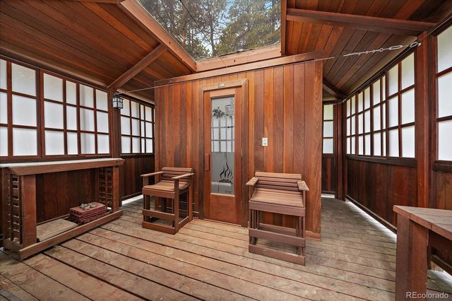 a view of a balcony with chairs and wooden floor