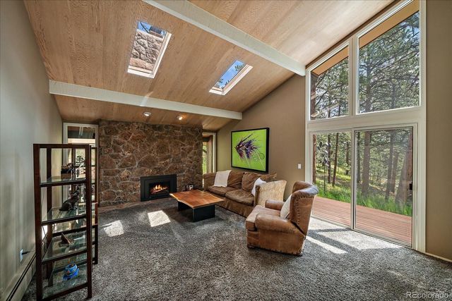 a living room with furniture a bookshelf and a large window