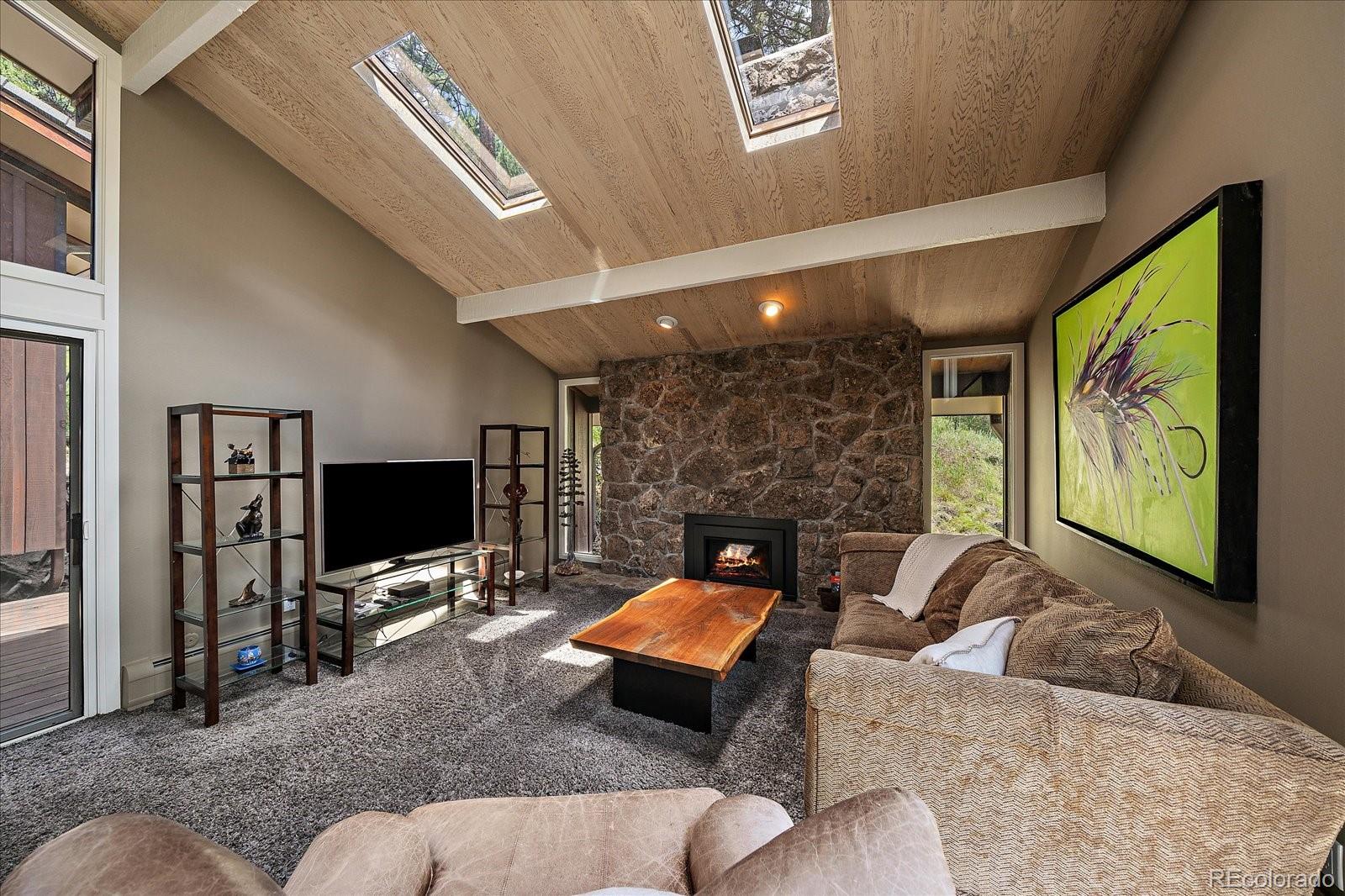 3251 Interlocken Drive Evergreen, CO 80439 - Photo 5 of 43 a living room with furniture flat screen tv and a fireplace