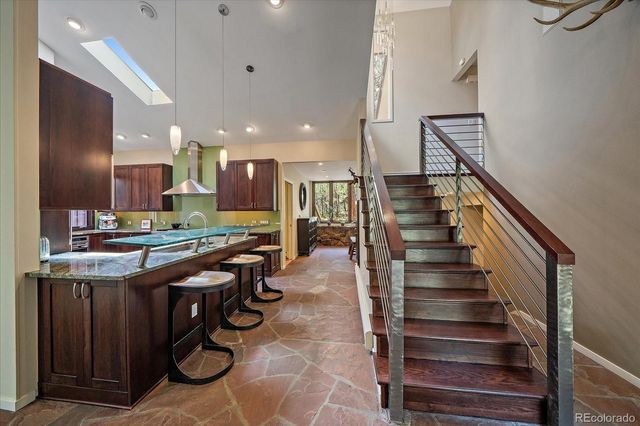 a kitchen with stainless steel appliances kitchen island granite countertop a stove and a view of living room