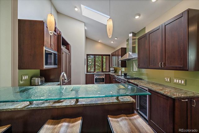 a kitchen with stainless steel appliances granite countertop a sink stove and cabinets