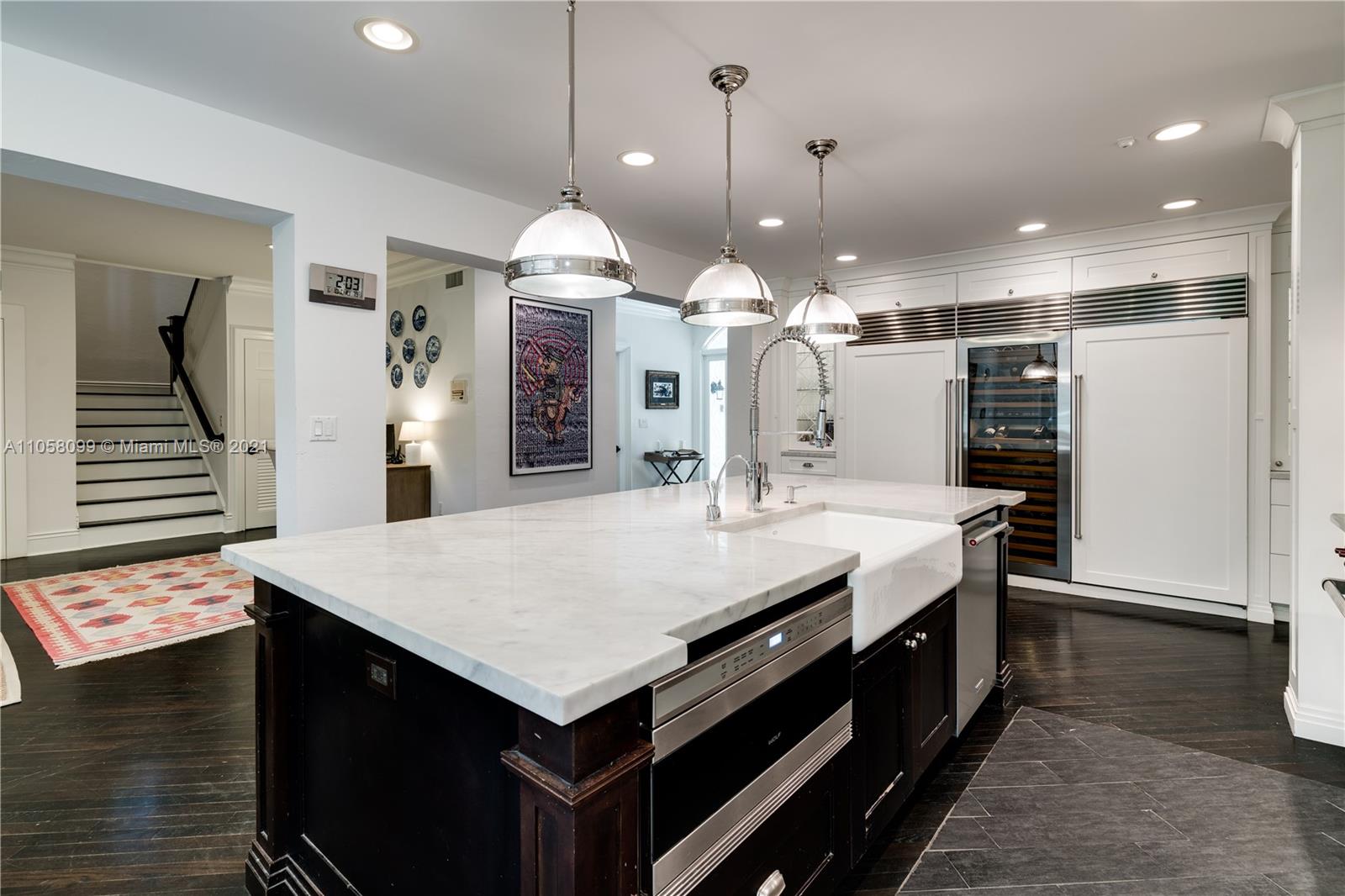 4288 Douglas Road Coconut Grove, FL 33133 - Photo 18 of 69 a large kitchen with kitchen island a sink stainless steel appliances and a chandelier