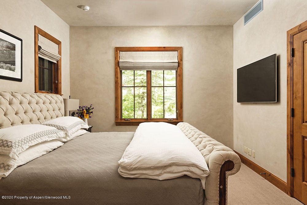 32 Prospector Road Aspen, CO 81611 - Photo 14 of 19 a bedroom with a large bed and a flat screen tv