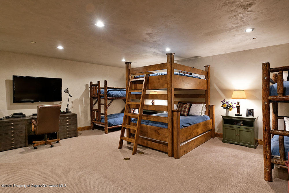 32 Prospector Road Aspen, CO 81611 - Photo 16 of 19 a bedroom with furniture and a flat screen tv