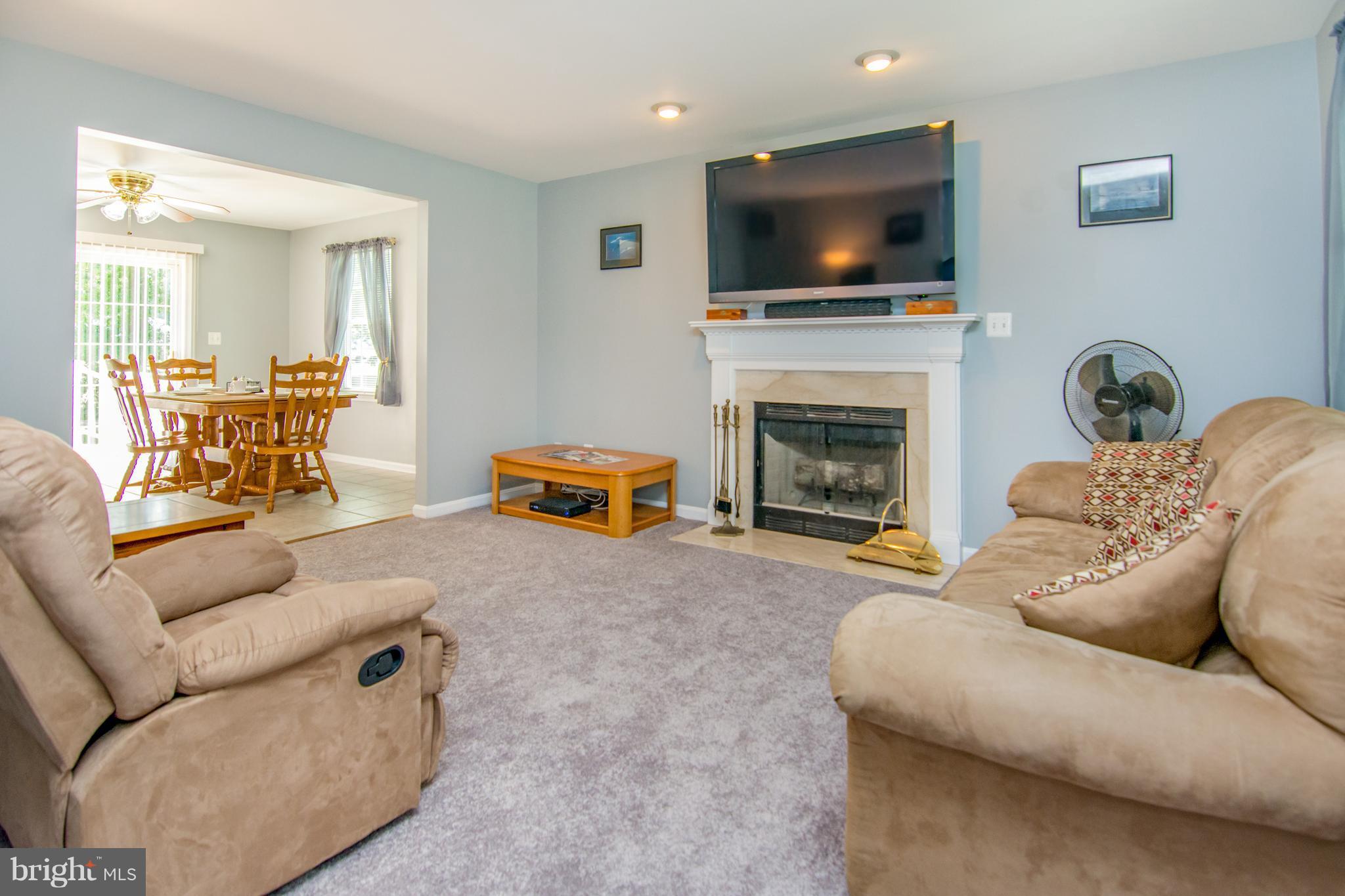 909 Back River Neck Road Baltimore, MD 21221 - Photo 8 of 21 a living room with furniture a flat screen tv and a fireplace