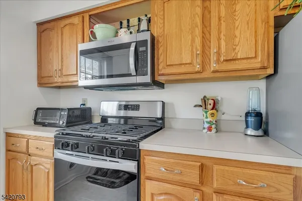 a kitchen with stainless steel appliances granite countertop a stove a microwave and cabinets