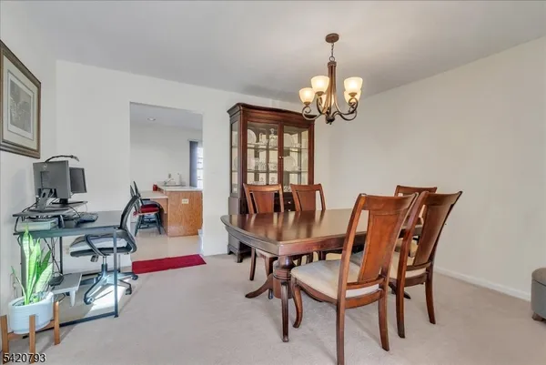 a dining room with furniture a chandelier and window