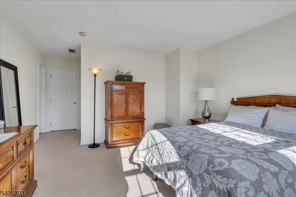 a bedroom with a bed and a flat tv screen on dresser