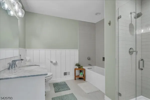 a bathroom with a granite countertop sink a toilet and shower