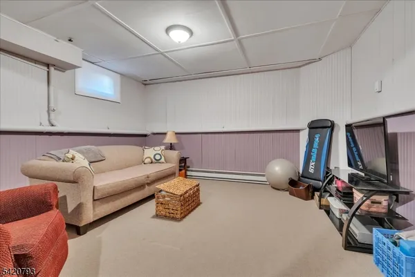 a living room with furniture a flat screen tv and gym equipment
