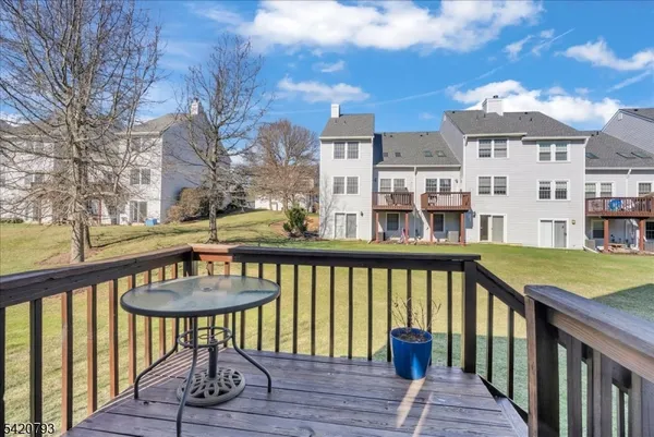 a view of a brick house with a chairs on deck