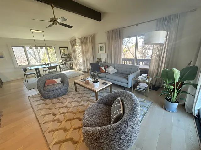 a living room with furniture a chandelier and a floor to ceiling window