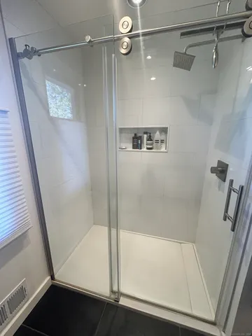 a bathroom with a shower and a glass door