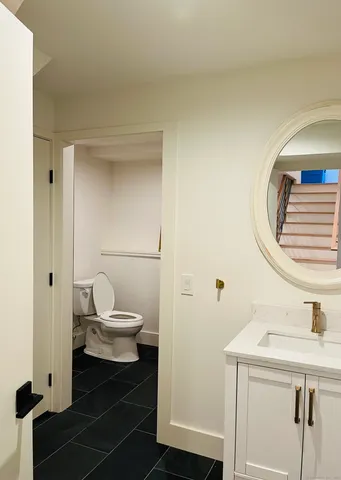 a bathroom with a toilet a sink and mirror