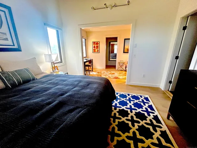 a bedroom with a bed and wooden floor