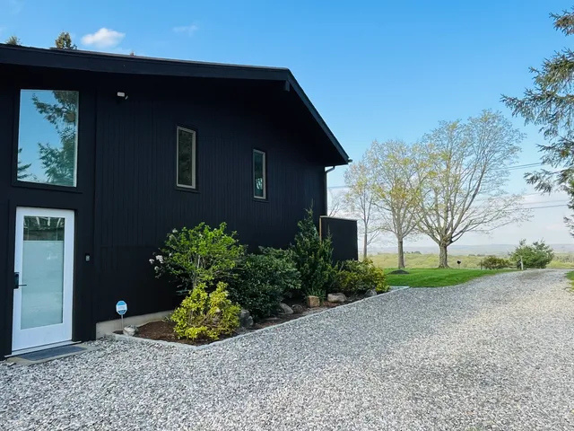 a front view of a house with a yard and potted plants