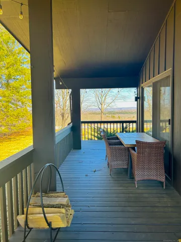 a view of a patio with couches chairs and wooden floor