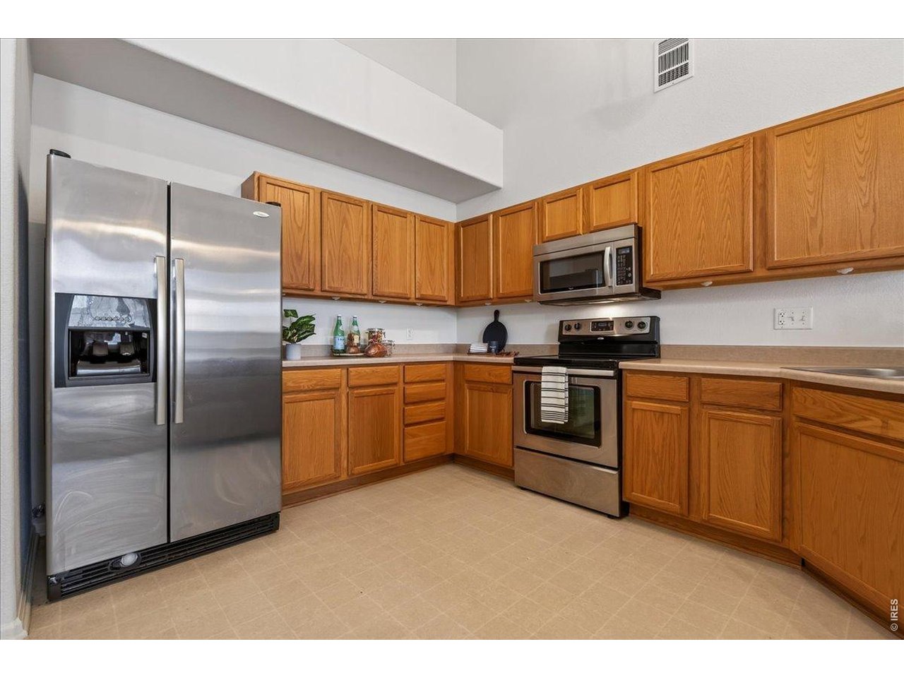10381 Cook Way, Unit 202 Thornton, CO 80229 - Photo 13 of 38 Stainless steel appliances and soaring ceilings add to the kitchen's bright and inviting atmosphere.