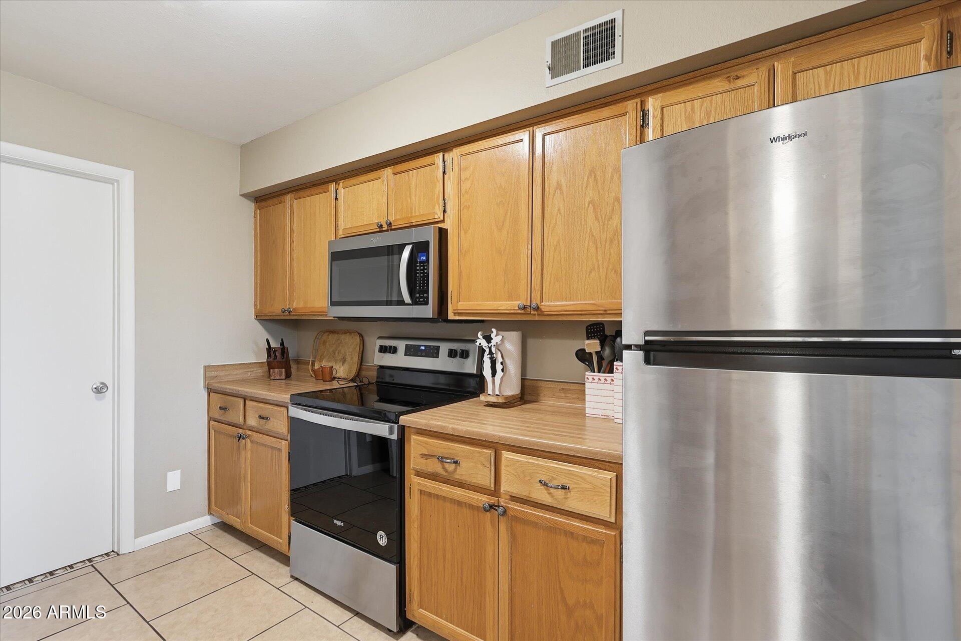 3270 South Goldfield Road, Unit 716 Apache Junction, AZ 85119 - Photo 3 of 36 a kitchen with stainless steel appliances a refrigerator sink and microwave